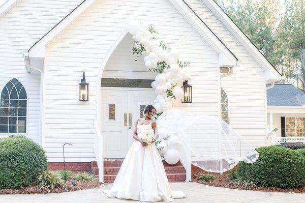 Bride in veil outside Evergreen Venue chapel in Rainbow City, Alabama