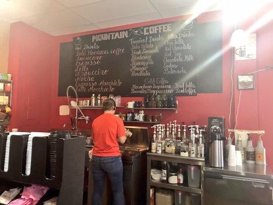 Inside. Owner is making coffee for customer. Menu is shown at the back.