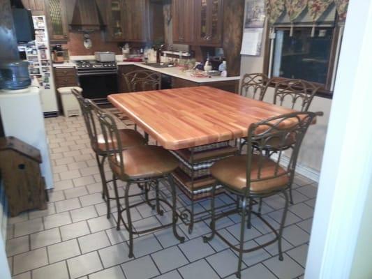 Table and bar stools. Solid Mahogany 40x60 top with wrought iron frame and baskets for storage. Stools have leather seats.