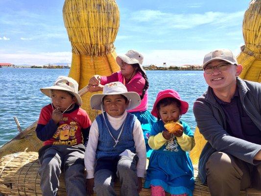 Local Uro floating island boat trip with local children at Lake Titicaca.