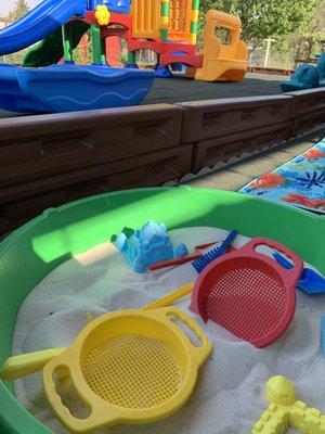 Outside sensory sand box under our covered patio next to our large commercial playground in our fenced in yard.