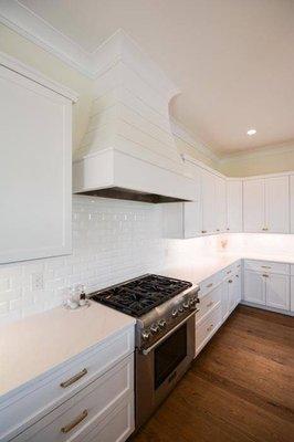 All white kitchen including white quartz and white subway tile.