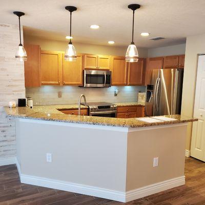 Beautiful gourmet kitchen featuring new granite countertops with ivory glass subway tile and LED puck lighting under cabinets.