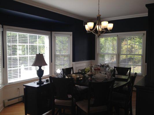 Crown mouldings and shadow box mouldings along with Navy blue upper walls updated this beautiful dining room