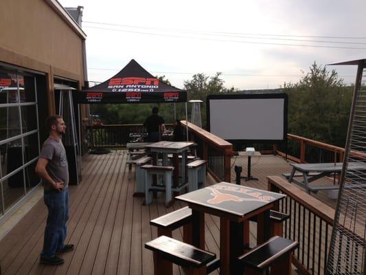 Outdoor patio showing sports on projection screen