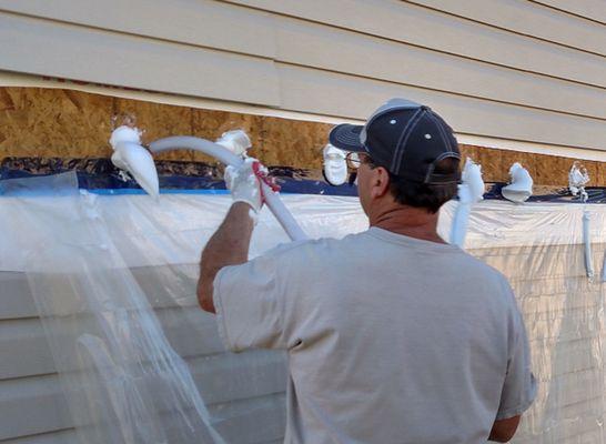 Installing RetroFoam. Removed a section of vinyl siding, drill holes, inject foam, plug house, seal vapor barrier and re-install siding.