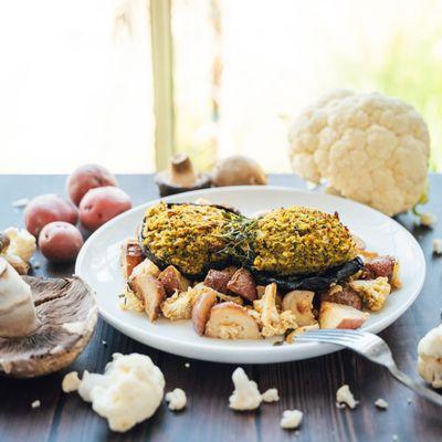 Stuffed Mushrooms with cheese and herb filling served with roasted garlic potatoes and roasted cauliflower