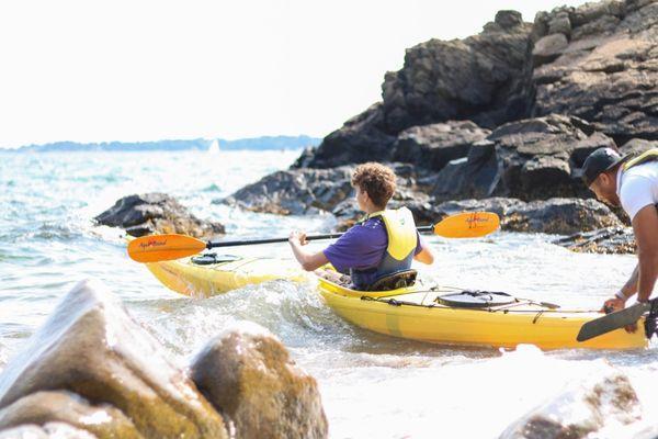 Student going out kayaking from beach on Landmark high school campus.