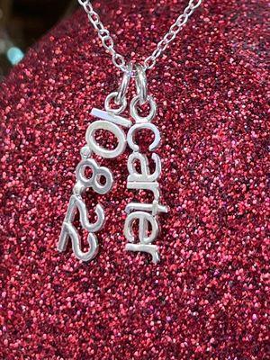 Custom designed necklaces featuring personalized names and dates.