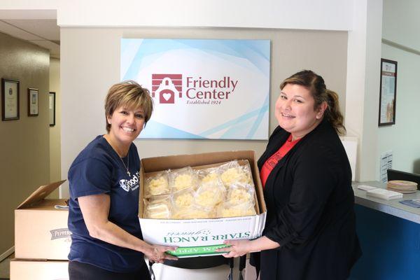 Volunteer dropping off food donations at the Friendly Center.