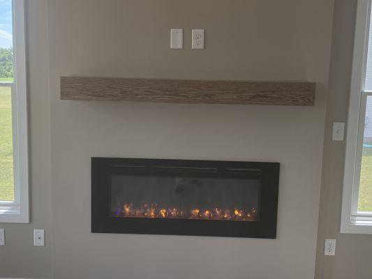 Electric fireplace with custom solid red oak mantle.