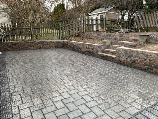 Two tier retaining wall with paver patio below.