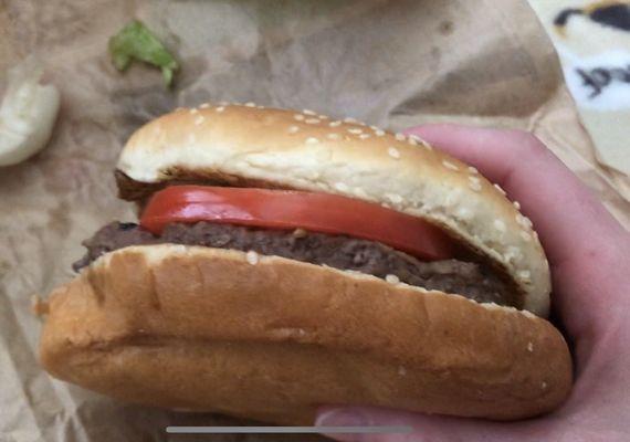 A thick, unsquished burger with a bright beautiful tomato