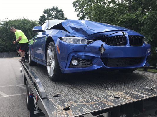 Car on tow truck. Don't worry the driver strapped down the wheels before moving the truck.