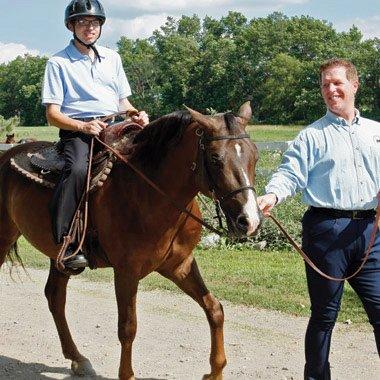 A clinician providing therapy in an innovative way with a client at our farm.