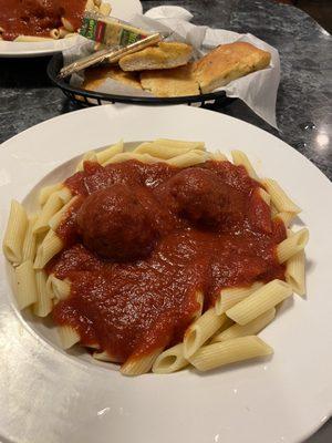 Pasta dinner with meatballs comes with a basket of garlic bread