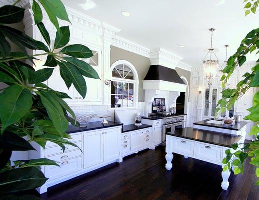 A beautiful white kitchen and contrasting textured countertop by Showcase Kitchens and Baths