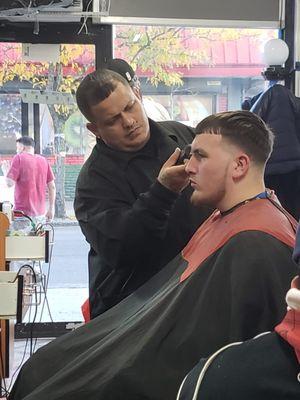 Inside barber shop, barber with a client