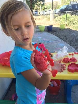 Doing her own thing - enjoying the shade & the play dough, and letting her imagination lead her.