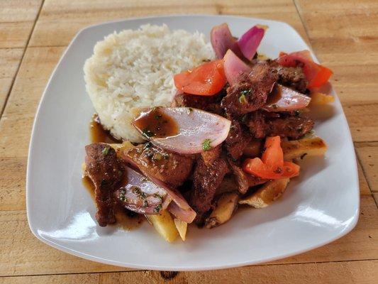 Lomo Saltado - Sauteed beef, red onions, tomatoes, french fries served with white rice.