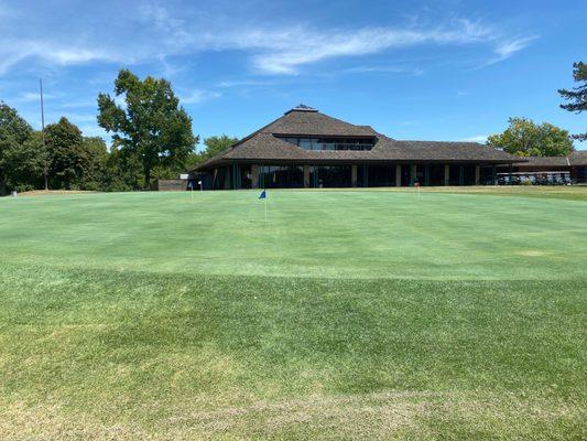 Practice putting green with view of the Pro Shop