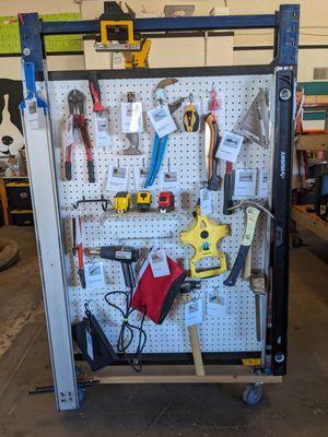 Assorted hand tools: hammers, wrenches, measuring tapes, levels, speed squares, heat guns, glue guns.