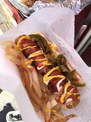 Only $3. Bacon wrapped hotdog topped with grilled onions, bell peppers, relish, jalapeños, mayo, ketchup, mustard, and love.