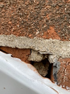 Chimney with visible cracks and missing mortar