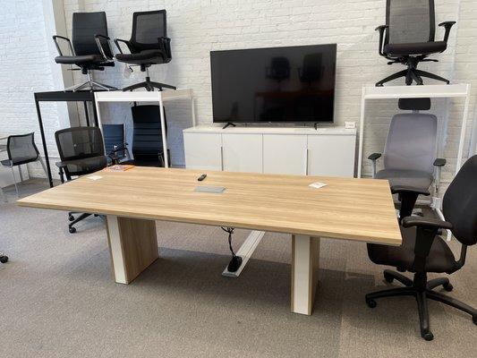 Desk Makers Malibu Conference Table with a power module in the center and wire management on the floor.