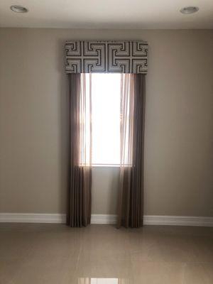 Light filtering cellular shade with decorative, sheer drapery side panels, and a fabric-wrapped cornice.