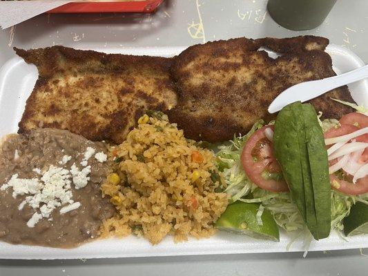 Milanesa de pollo platter.  Fried chicken, salad, beans and rice