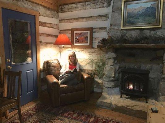 Reading by the log cabin fireplace