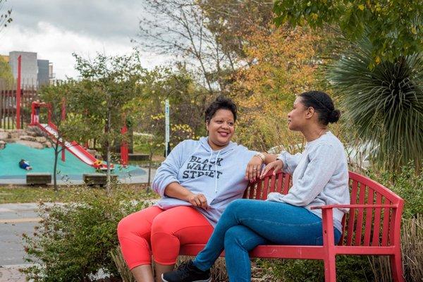 Friends catch up while their daughters hula hoop at Durham Central Park. Photo credit: Ryan Moeller Photography.