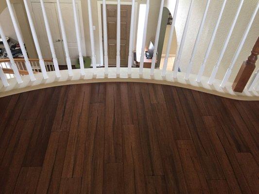 Wood installation upstairs with curved bannister