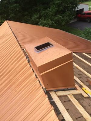 Copper colored metal roof with chimney work.  Beautiful  roof color..transformed the whole  look of this country property...