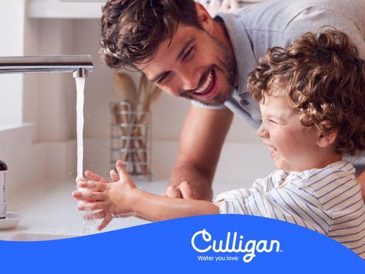 Father and son at faucet using Culligan water