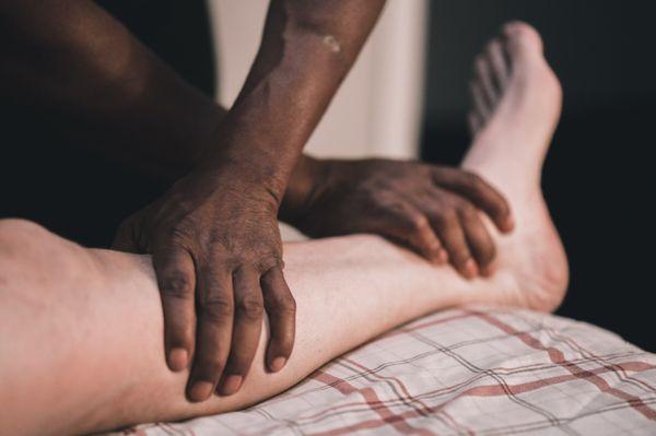 Clinton Muhammad massaging a patient's leg