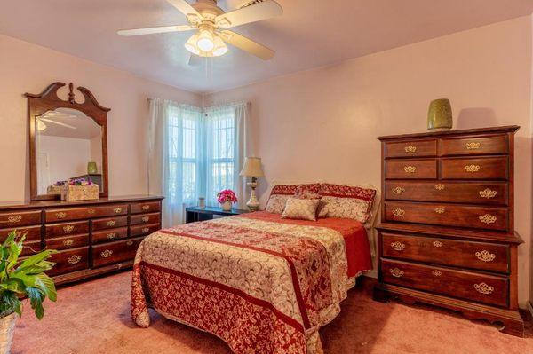 Bedroom with ceiling fan and ample closet space.