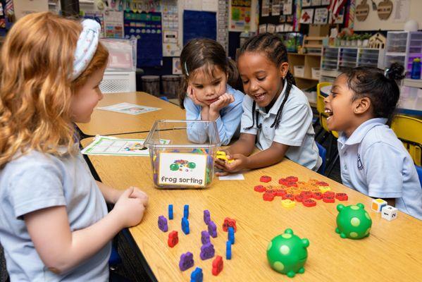 Pre-K students share a laugh in their sorting center.