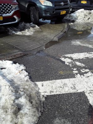 Car blocking access to  curb and pavement.