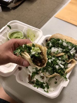 An order of three tacos: carnitas, bistec, y pollo.