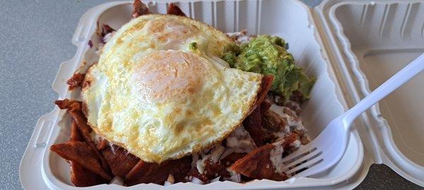 Chilaquiles plate with a side of guac and eggs