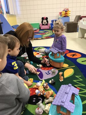 The Director in the classroom playing with the children.