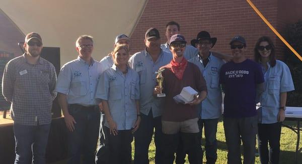 The fly fishing contest winner of the largest trout caught of 19.5 inches, along side the event team of the event.