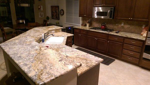 Granite countertops installed here with a multilevel bar top. We set the matching backsplash as well.