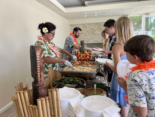 Buffet of the Hawaiian food and two servers