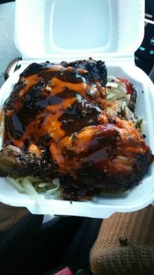 Jerk chicken over cabbage with jerk sauce and hot pepper sauce