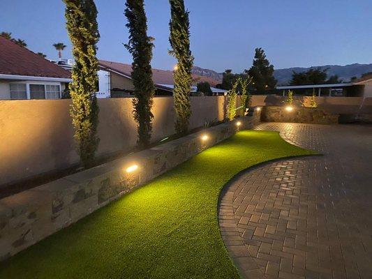 Our client will have a stunning, low-maintenance yard after this backyard makeover. The project included a retaining wall, artificial turf,