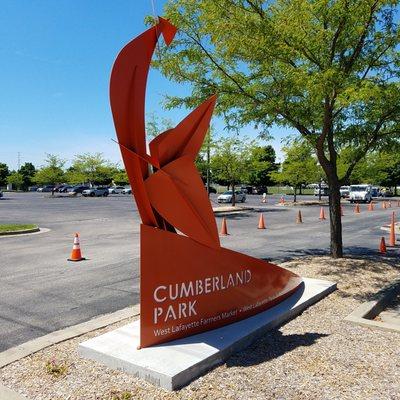 large parking area with "Rooster" by Jeff Laramore (2017) to welcome Farmer's Market