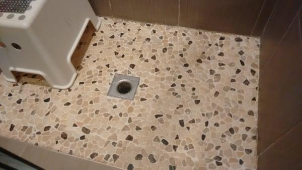 Improperly installed shower.  LEAKS!  Wrong drain (outdoor).  No hot mop.  Side tiles installed before floor.